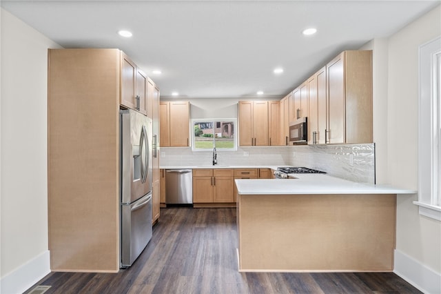 kitchen featuring appliances with stainless steel finishes, sink, decorative backsplash, dark hardwood / wood-style floors, and light brown cabinetry