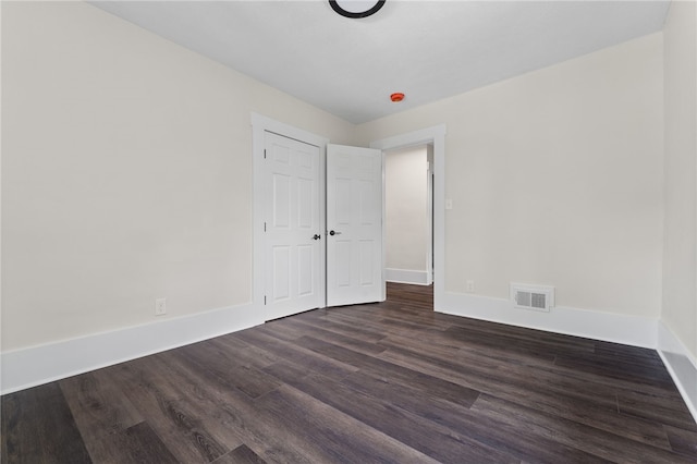 unfurnished room with dark wood-type flooring