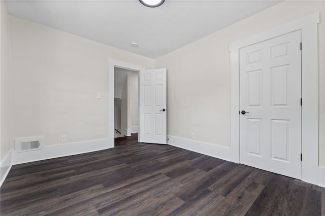 unfurnished bedroom featuring dark hardwood / wood-style floors and a closet