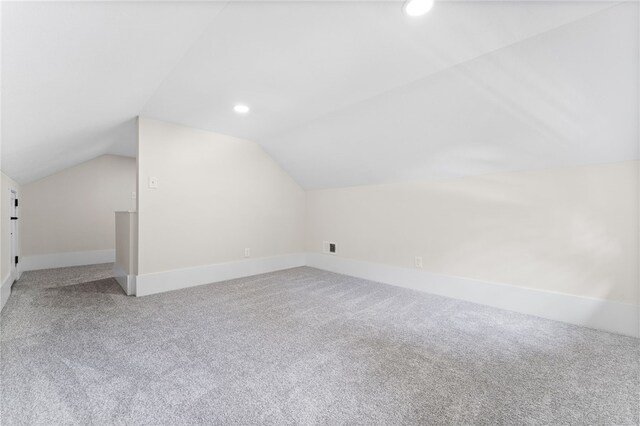 bonus room with vaulted ceiling and carpet floors