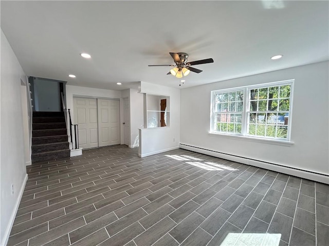 unfurnished living room featuring ceiling fan and a baseboard heating unit