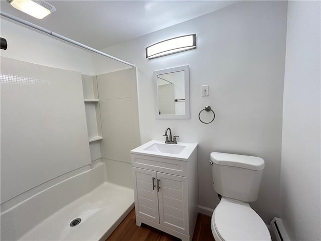 bathroom with toilet, a shower, hardwood / wood-style floors, a baseboard radiator, and vanity