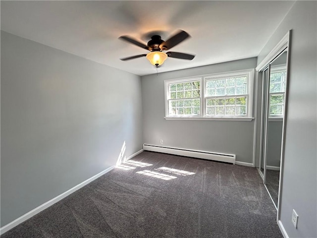 empty room featuring ceiling fan, a baseboard radiator, and dark colored carpet