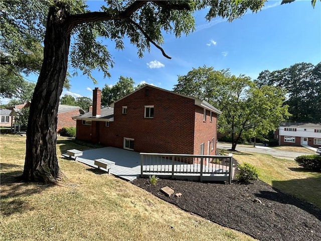 view of home's exterior featuring a wooden deck and a yard