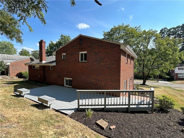 back of house with a deck and a yard