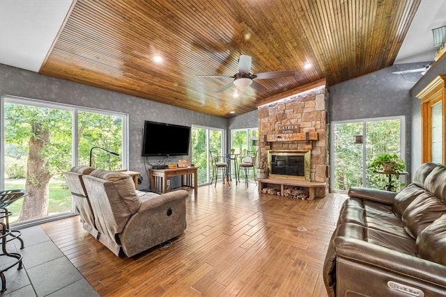 living room with ceiling fan, a fireplace, light wood-type flooring, wood ceiling, and high vaulted ceiling