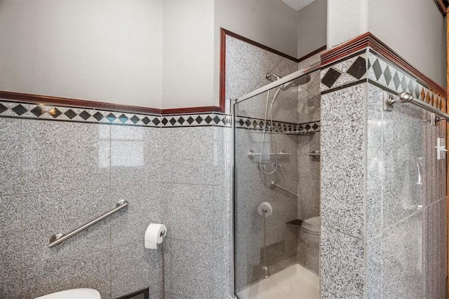 bathroom with toilet, tile walls, and walk in shower