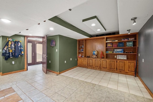 unfurnished living room featuring light tile patterned floors and french doors