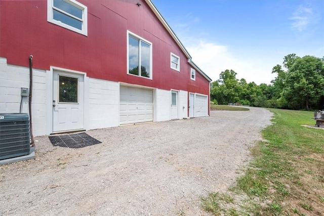 view of side of property with central AC unit and a garage