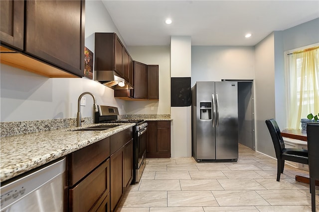 kitchen with sink, light stone countertops, dark brown cabinetry, appliances with stainless steel finishes, and light tile patterned floors