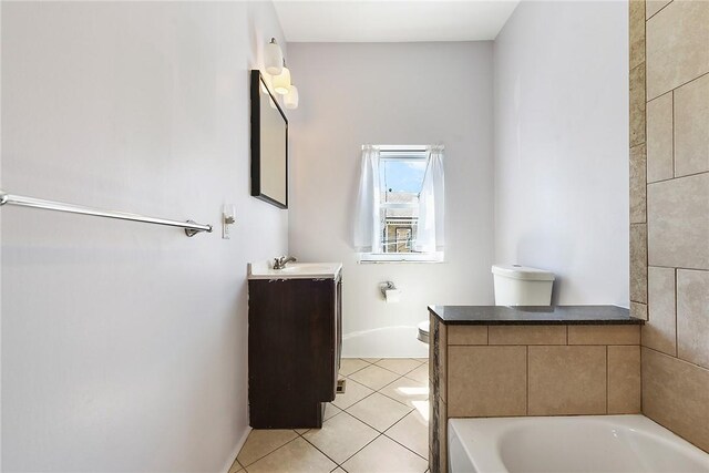 bathroom featuring tile patterned floors, toilet, vanity, and a bathtub