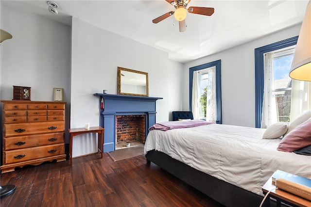 bedroom featuring ceiling fan, multiple windows, and dark hardwood / wood-style flooring