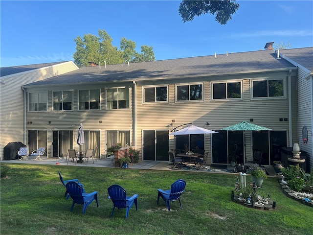 back of property featuring a patio area and a yard