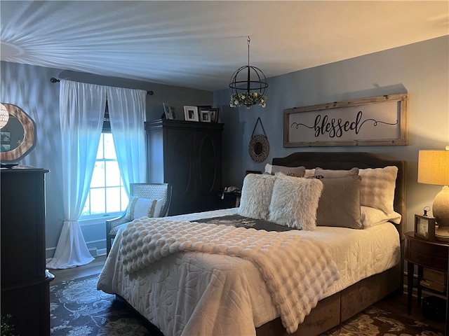 bedroom featuring dark wood-type flooring and an inviting chandelier