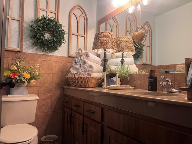 bathroom featuring tile walls, vanity, and toilet