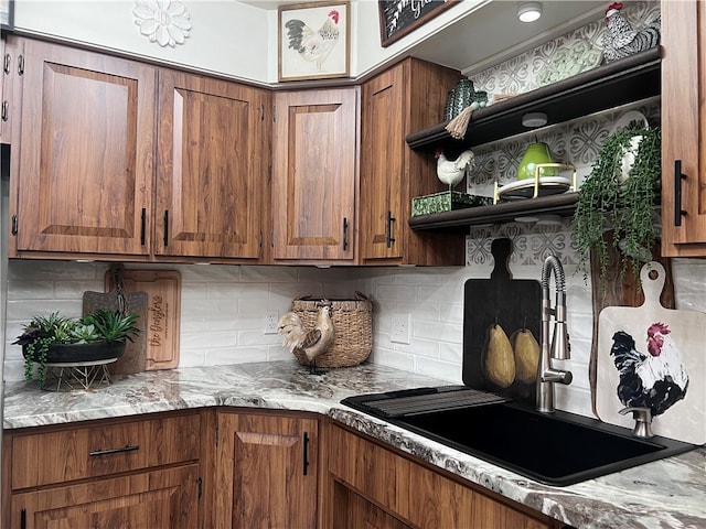 kitchen with backsplash, sink, and light stone counters