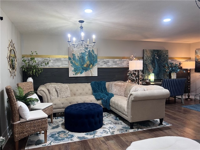 living room featuring wood-type flooring, a textured ceiling, and a notable chandelier