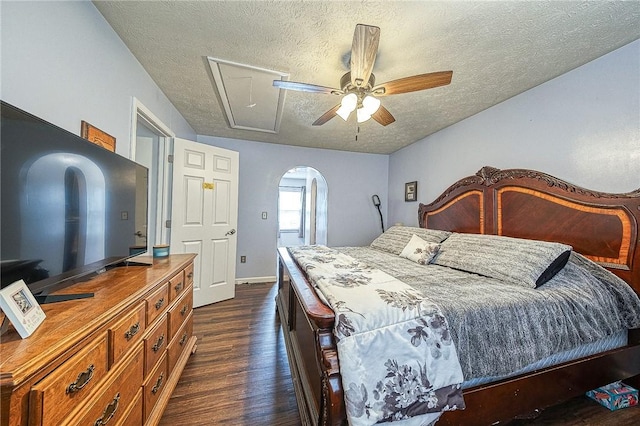 bedroom featuring attic access, baseboards, dark wood-style floors, ceiling fan, and a textured ceiling