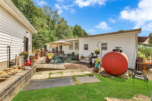 rear view of house with a wooden deck and a patio