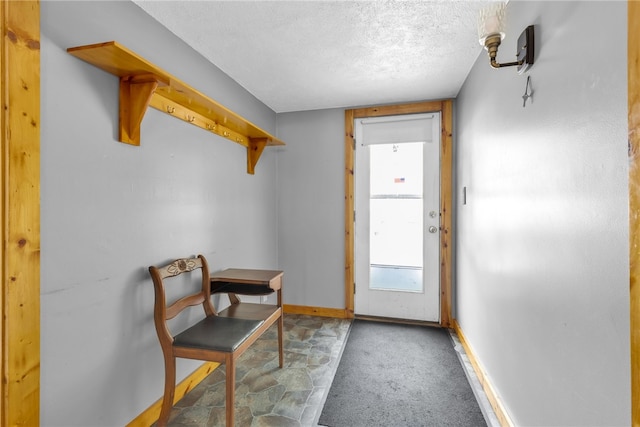 entryway with carpet floors and a textured ceiling