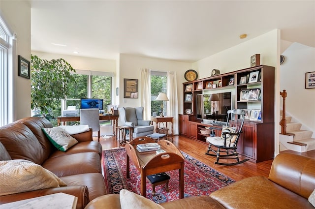 living area with stairway and wood finished floors