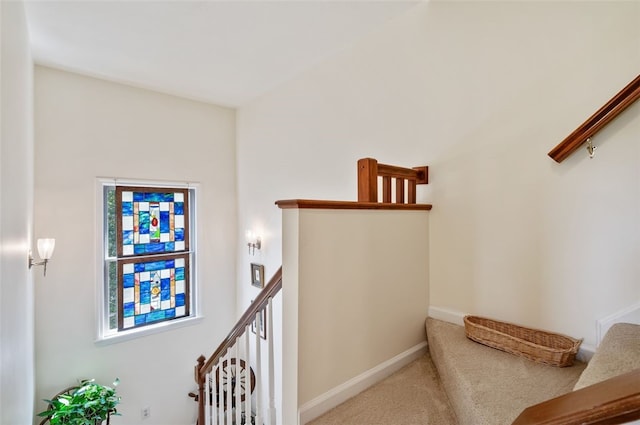 staircase featuring carpet floors and baseboards