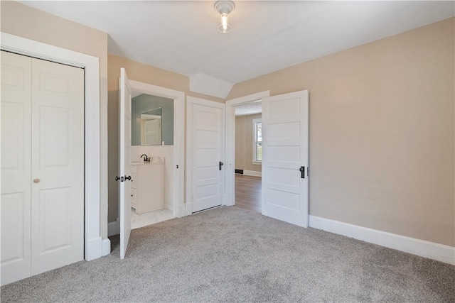 unfurnished bedroom featuring light colored carpet and a closet