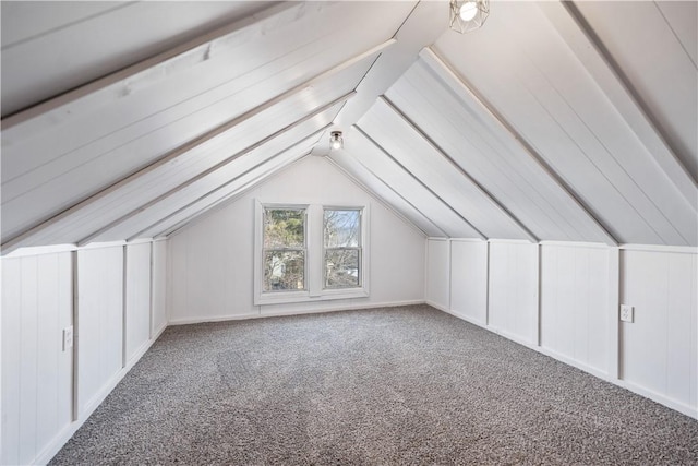 additional living space with carpet flooring and vaulted ceiling