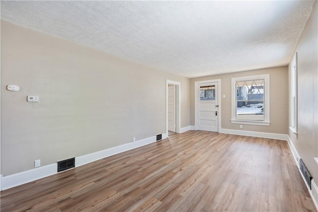 empty room featuring light hardwood / wood-style floors and a textured ceiling