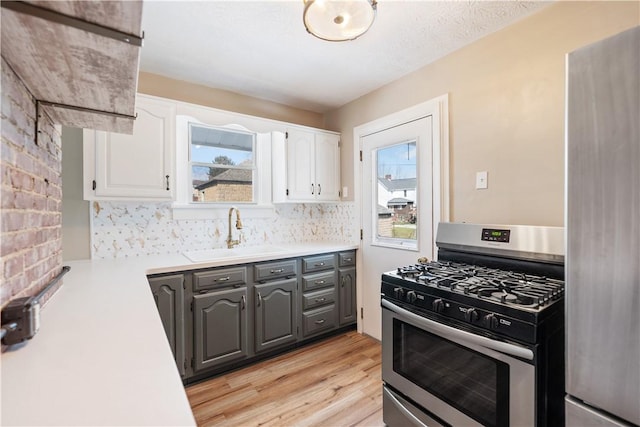 kitchen featuring white cabinets, appliances with stainless steel finishes, a wealth of natural light, and sink