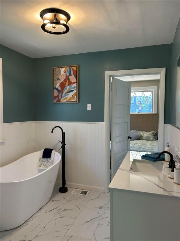 bathroom with a washtub and vanity