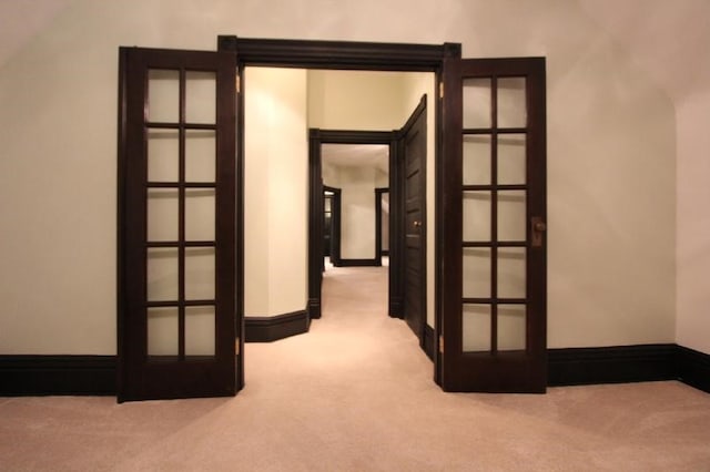 hallway with french doors and light colored carpet