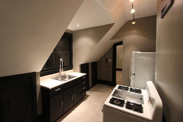 kitchen with white gas stove, refrigerator, vaulted ceiling, and sink