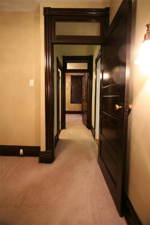 hall with light colored carpet