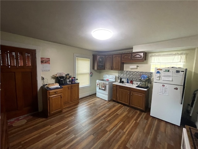 kitchen with white appliances, dark hardwood / wood-style floors, and backsplash