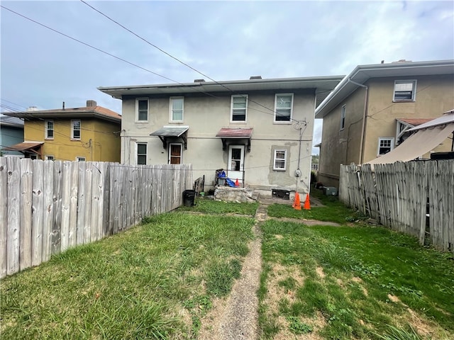 rear view of property featuring a yard