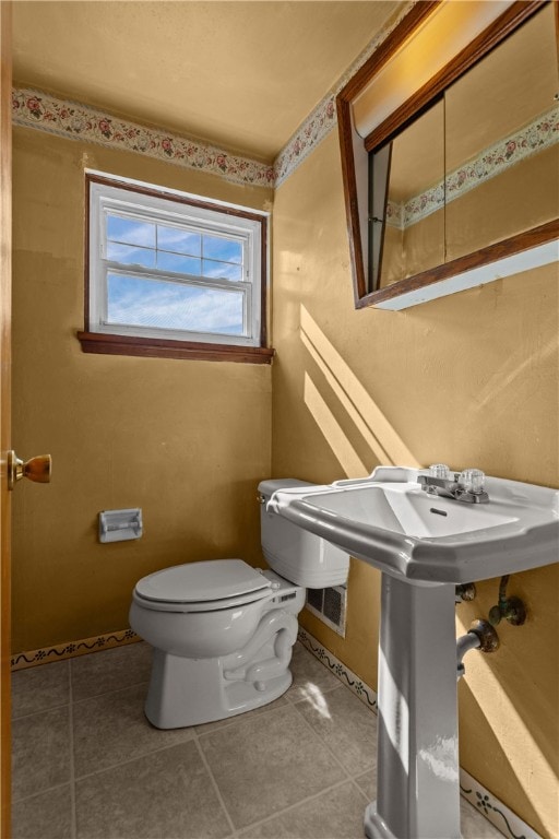 bathroom with toilet and tile patterned floors