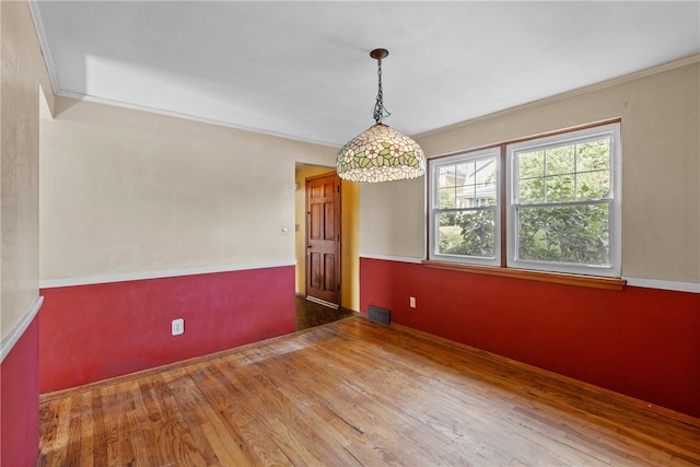 empty room featuring ornamental molding and wood-type flooring