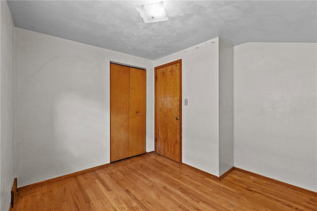 unfurnished bedroom with light hardwood / wood-style flooring and a closet