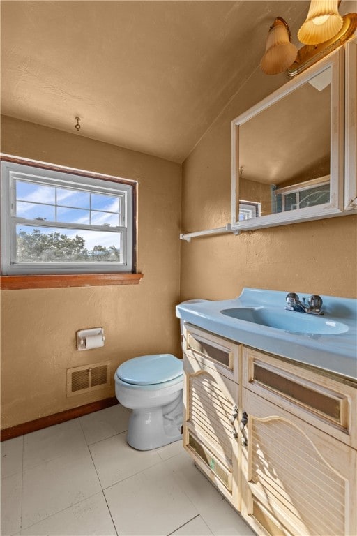 bathroom with vanity, lofted ceiling, tile patterned flooring, and toilet