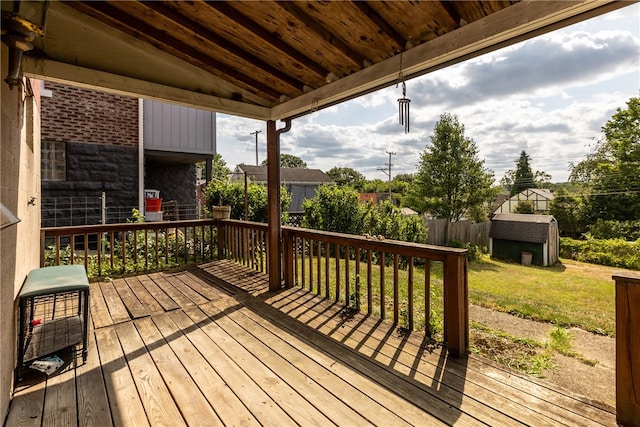 deck with a storage shed and a lawn