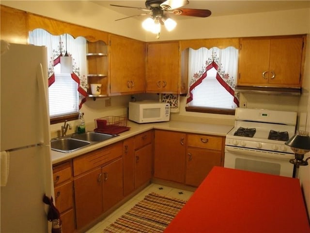 kitchen with light tile patterned floors, white appliances, sink, and ceiling fan