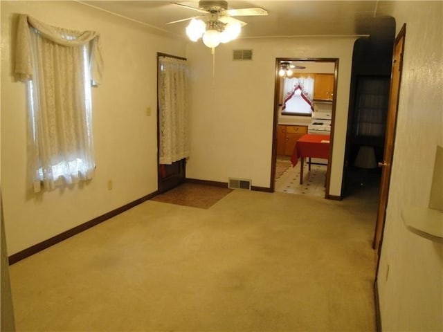 tiled spare room featuring ceiling fan