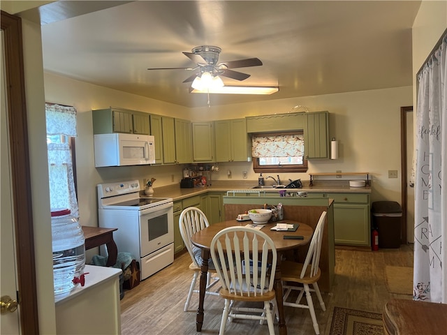 kitchen featuring ceiling fan, green cabinets, hardwood / wood-style flooring, and white appliances