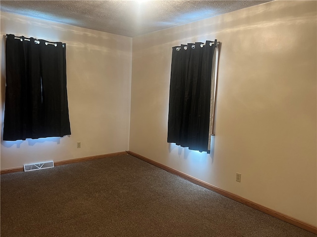 carpeted spare room featuring a textured ceiling