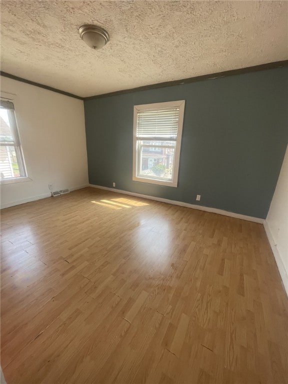 spare room featuring a textured ceiling and hardwood / wood-style floors