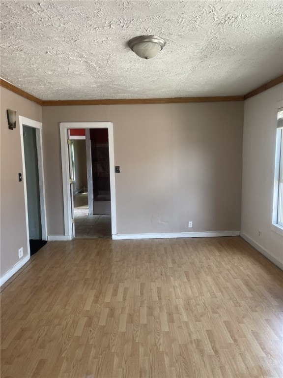 unfurnished room featuring hardwood / wood-style floors, ornamental molding, and a textured ceiling