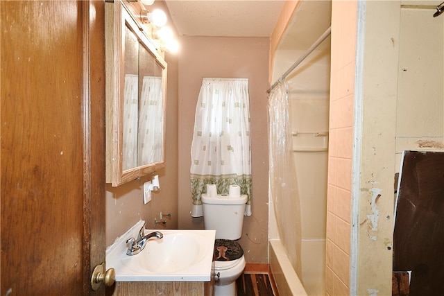 full bathroom with vanity, shower / bath combo, a textured ceiling, and toilet