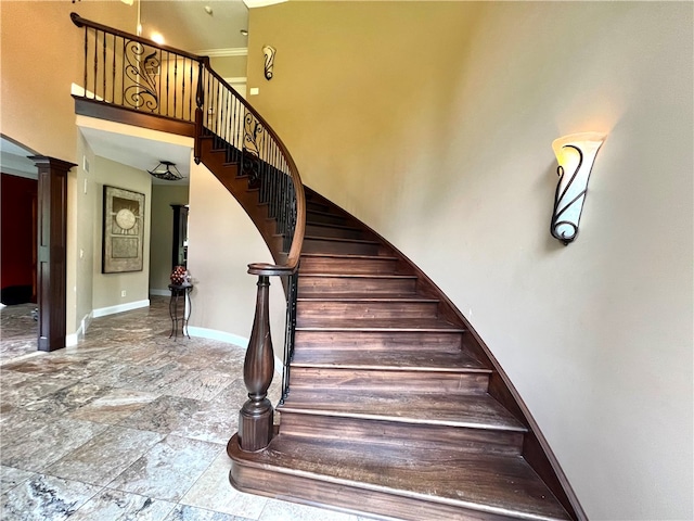 stairway featuring a towering ceiling, decorative columns, and tile patterned flooring