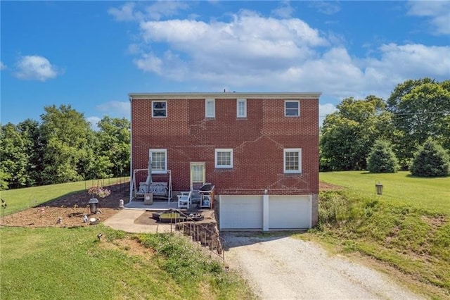 back of property featuring a garage and a yard